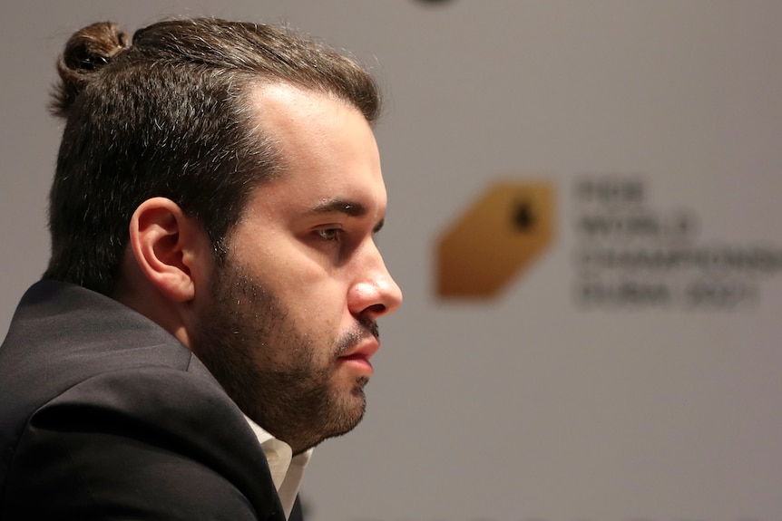 A profile picture of a pensive-looking chess player during a game in the world championship.