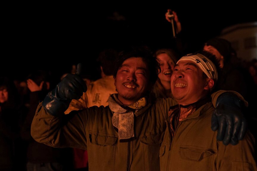 Two men embrace after taking part in the Nozawa Onsen Fire Festival