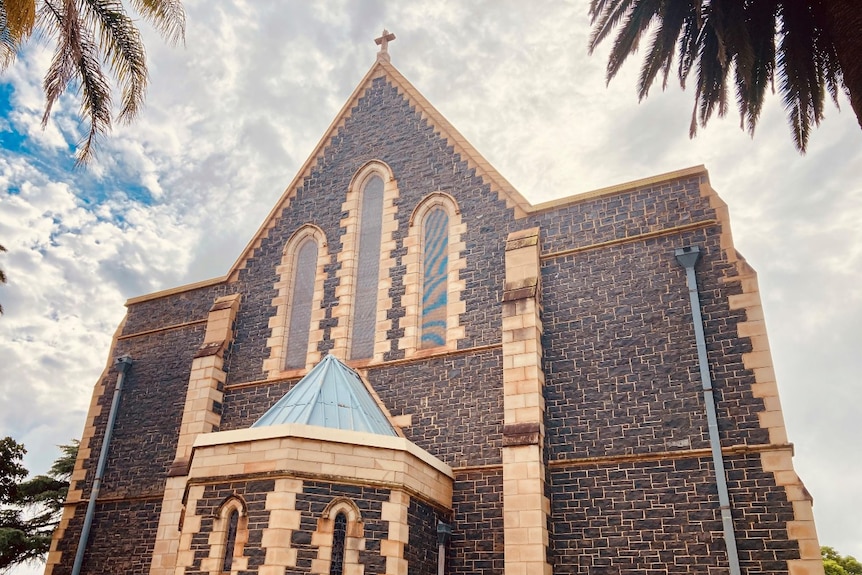 An old church with a cross on roof and arched windows