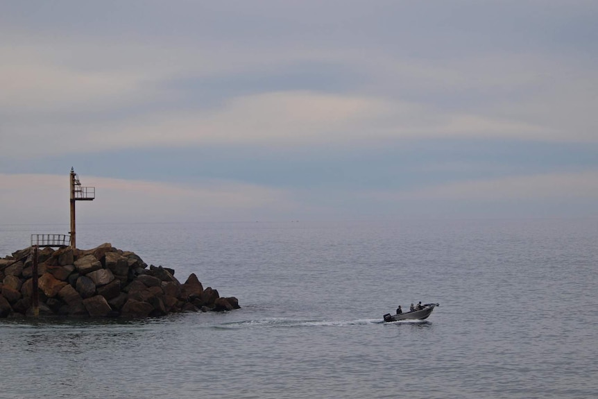 A fishing boat heading out from O'Sullivan Beach boat ramp
