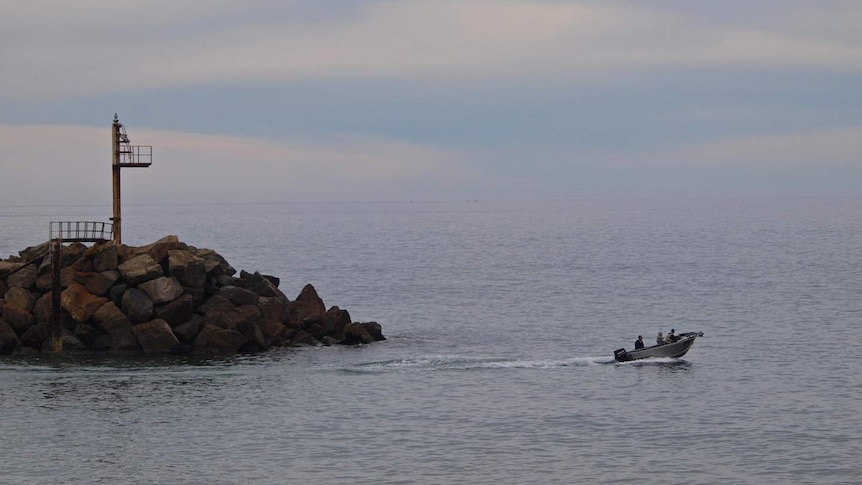 A fishing boat heading out from O'Sullivan Beach boat ramp