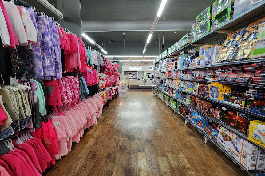 A shop aisle loaded with products on its shelves.