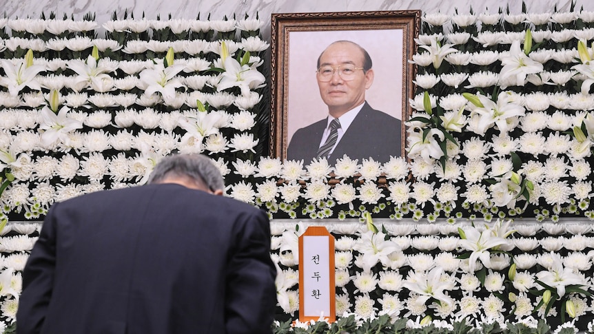 A man bows his head in front of a photo of former South Korean dictator Chun Doo-hwan.