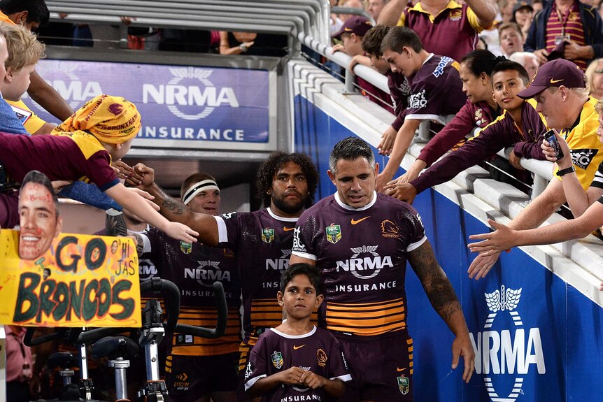Fans cheer the Brisbane Broncos onto the field at Lang Park against Sydney Roosters