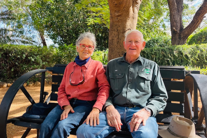 Jan and Tony Hetherington sit on a bench seat in their garden at Darriveen Station.