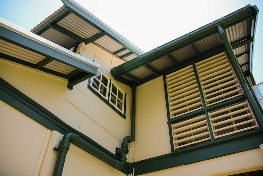 Corner showing louvered windows and large shaded roof