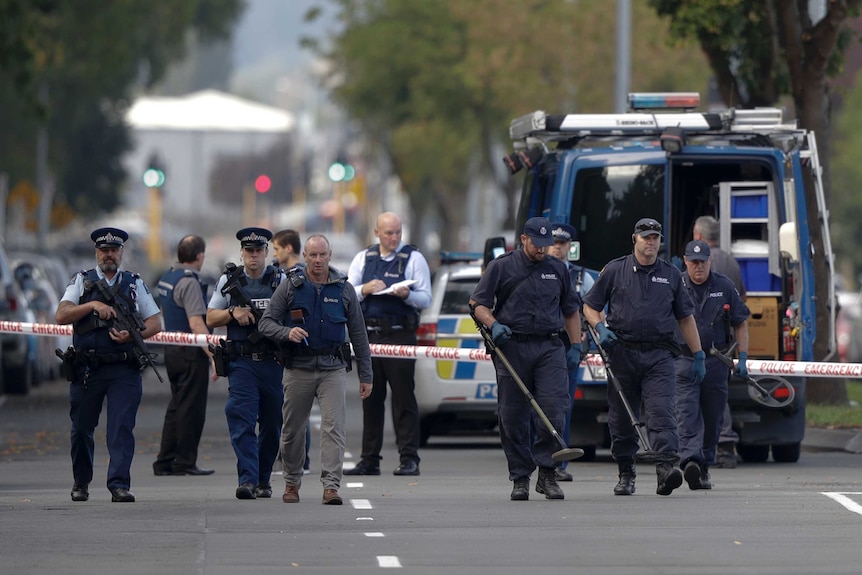 Police officers search the area near the Masjid Al Noor mosque, the site of one of the mass shootings.