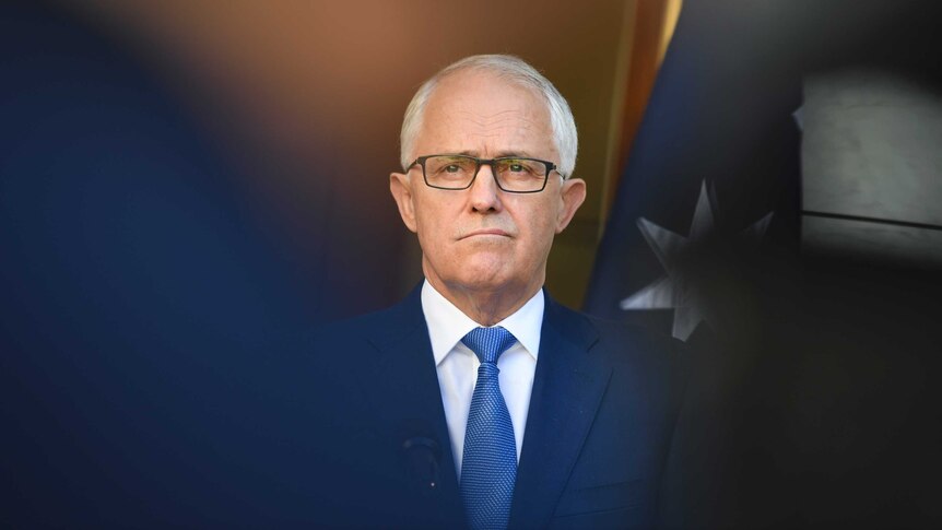 The Prime Minister stands in front of the Australian flag, Canberra 30 November 2017.