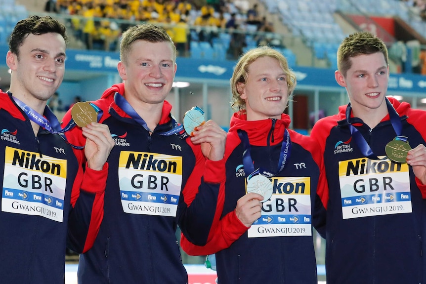 British men's relay team pose with their gold medals.