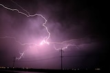 Lightning explodes over power lines.