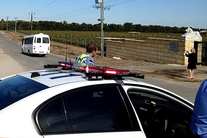 Police escort people from a property in Carabooda in Western Australia following a raid on May 5, 2014.