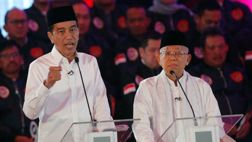 Indonesian President Joko Widodo delivers a speech dressed in white with running mate Ma'ruf Amin.