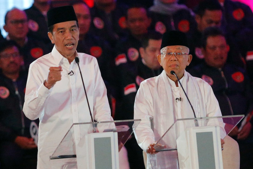 Indonesian President Joko Widodo delivers a speech dressed in white with running mate Ma'ruf Amin.