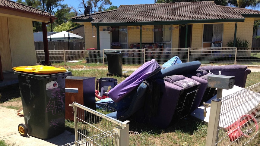 Furniture and rubbish bins fill the front yard of an abandoned home in the western Sydney suburb of Bidwill.