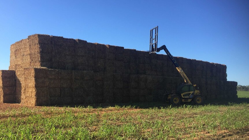 hay stacked next to a tractor