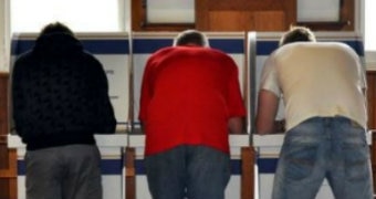 Three men vote at a polling station.