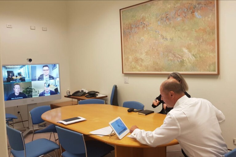 A man does a Zoom meeting in the office