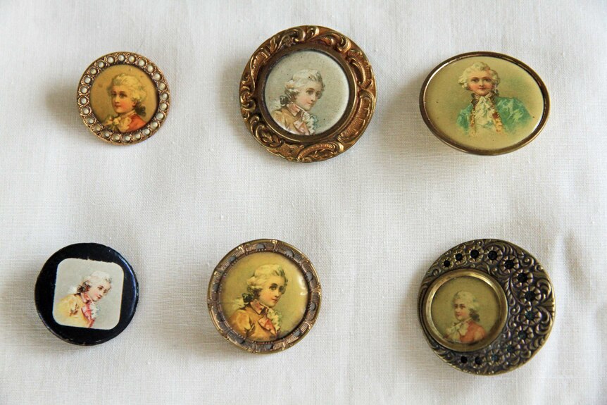 Six buttons featuring faces, on a white background.