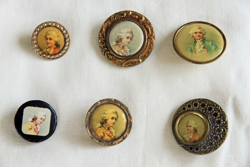 Six buttons featuring faces, on a white background.