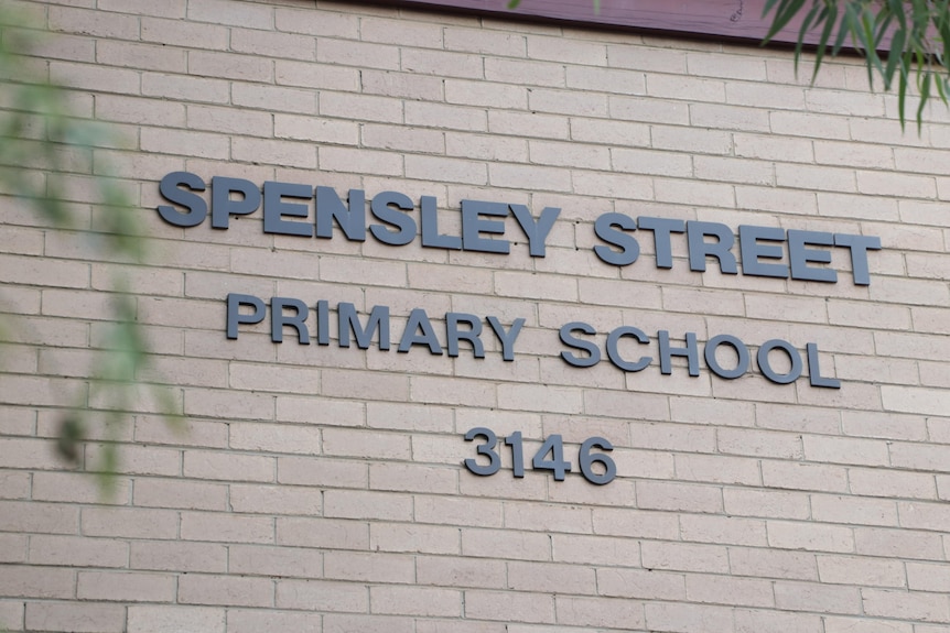 A sign on a brick wall bearing the name of Spensley Street Primary School.