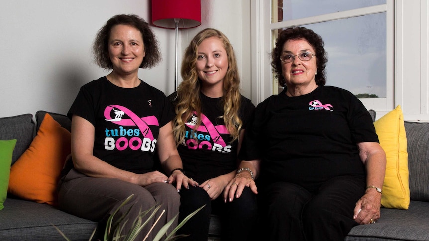 Linda Hodgson, Courtney Bower, and Suzanne Stessl sit on a lounge.