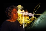 An aboriginal woman a sign saying Yeelirrie and a bug.