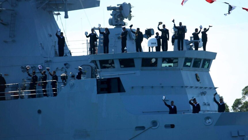 The crew of a Malaysian warship salute the crowd during the International Fleet Review.