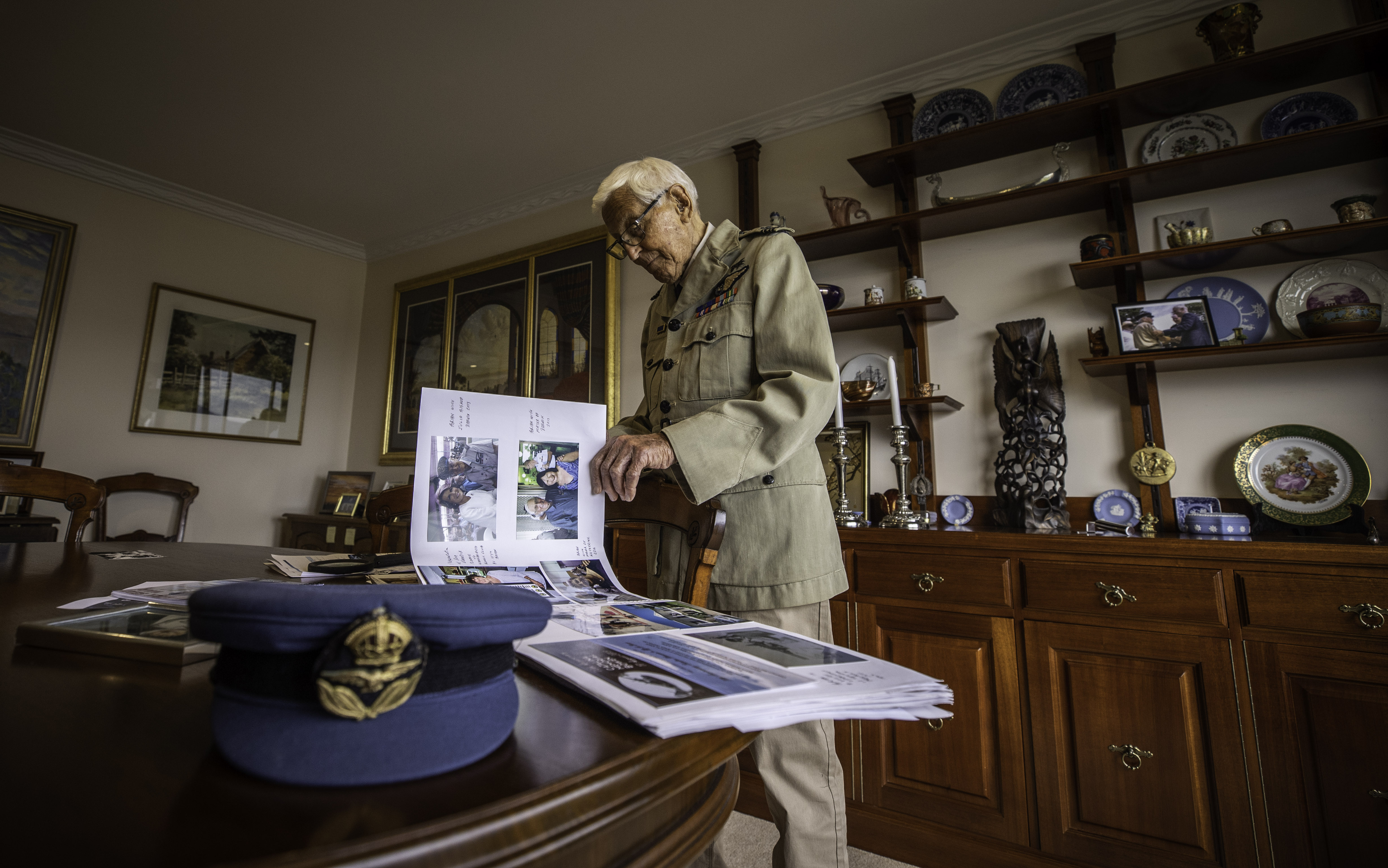 a war veteran flicking through a large book of photographs