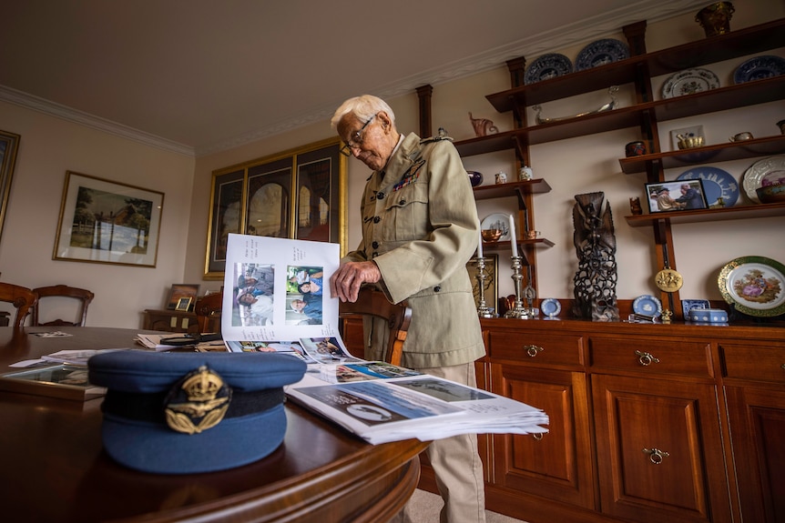 a war veteran flicking through a large book of photographs