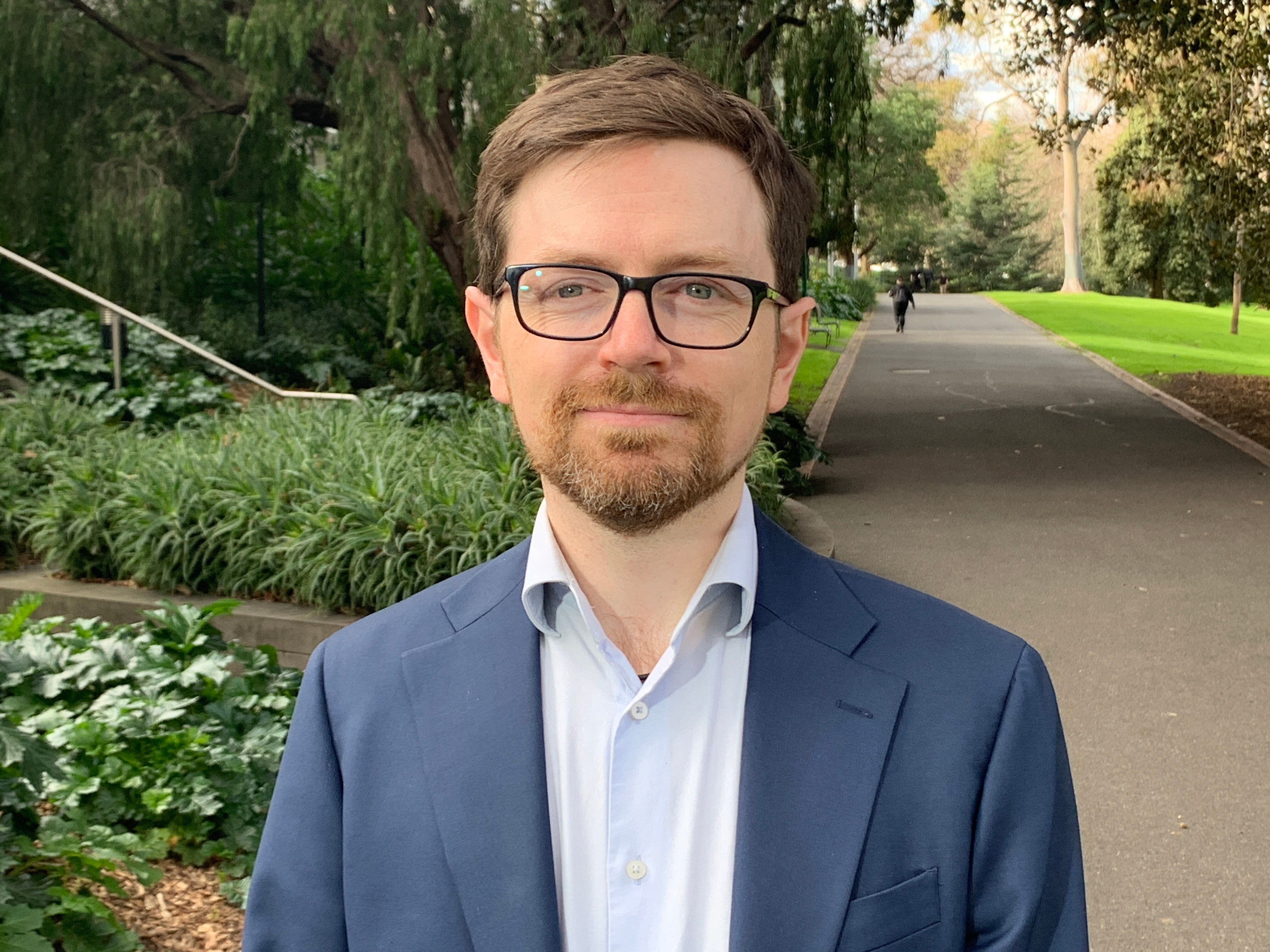 A man wearing glasses and a suit.