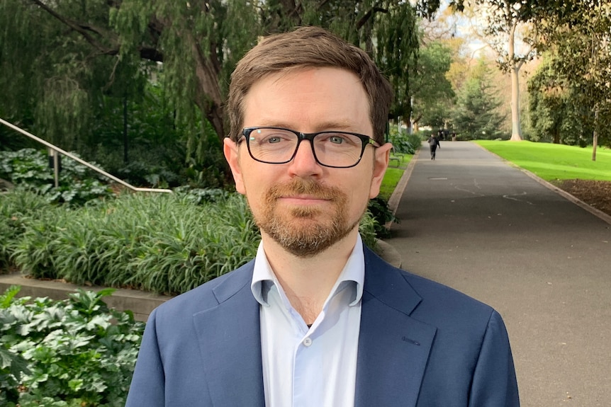 A man wearing glasses and a suit.