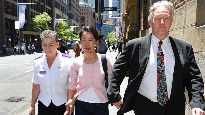 Kathy Lin, the wife of Robert Xie, leaves the NSW Supreme Court in Sydney with her husband's lawyer.