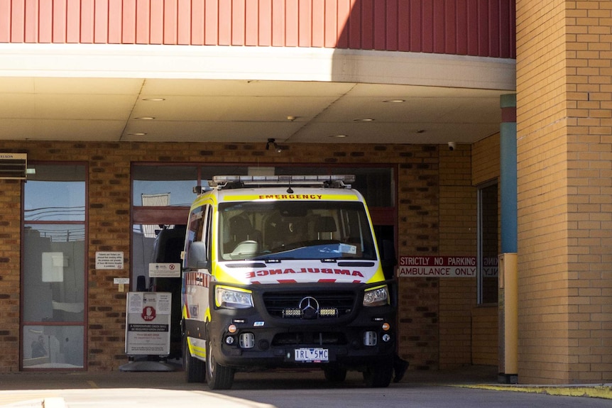an ambulance is parked at the entrance to a hospital emergency department