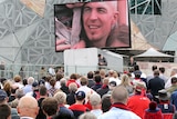 People at Federation Square in Melbourne watch Jim Stynes state funeral.