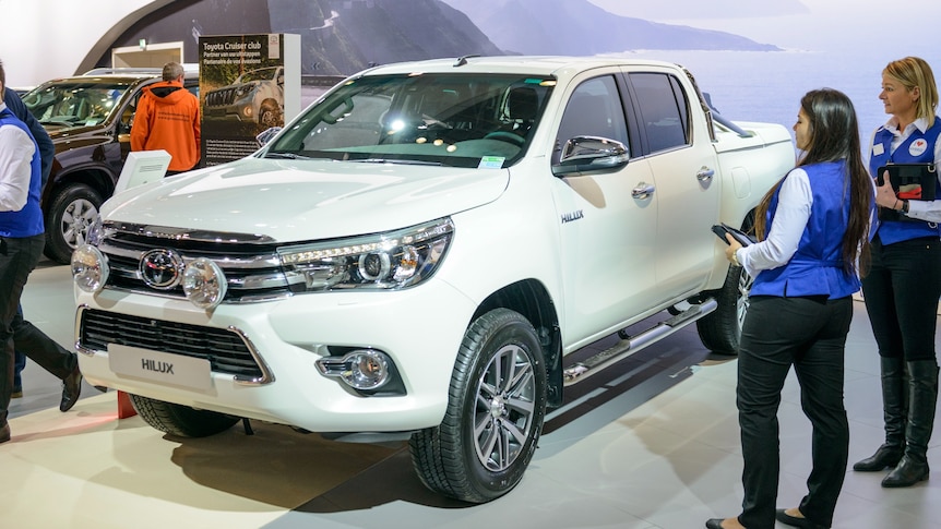 A white Toyota Hilux at a car show.