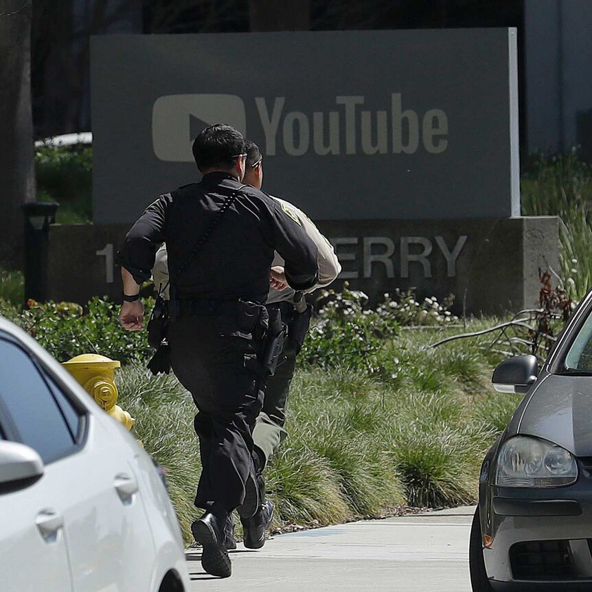 Officers run toward a YouTube office in San Bruno.