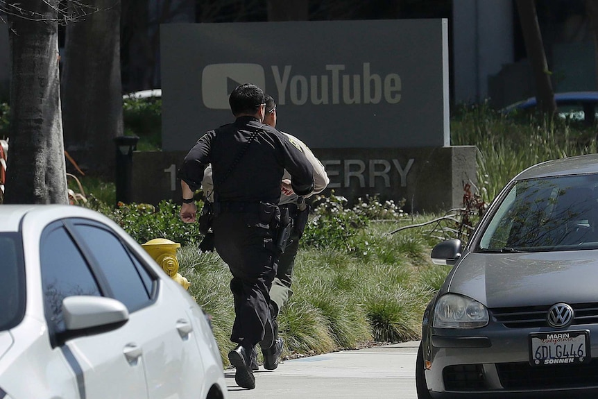 Officers run toward a YouTube office in San Bruno.