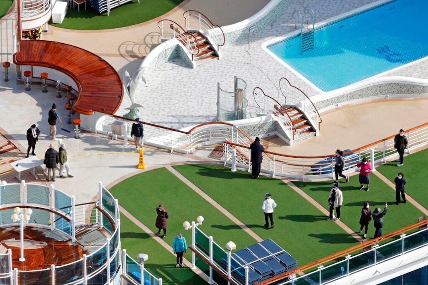An aerial photo shows section of pastel-coloured rooftop deck of the Diamond Princess ship, with a pool, bar, and fake grass.