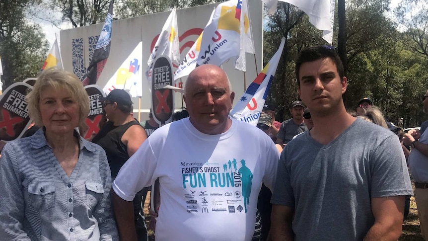 Three people standing in front of union banners calling for a boycott of Streets ice cream.