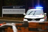 A police car blocks off the entrance to a government facility 