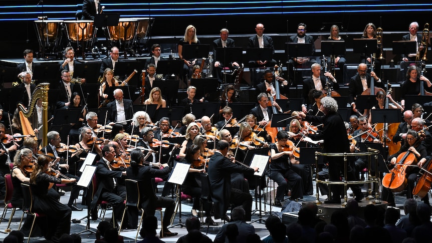 A full symphony orchestra mid-performance at London's Royal Albert Hall.