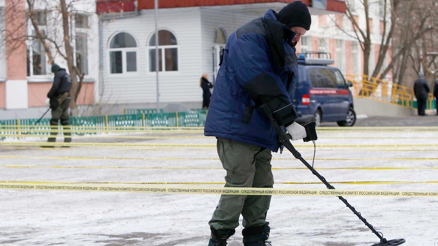 Russian security service members use mine and metal detectors outside a Moscow school