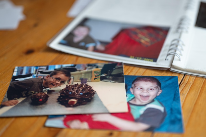 Photos of Bryce as a young boy sit in front of a photo album.