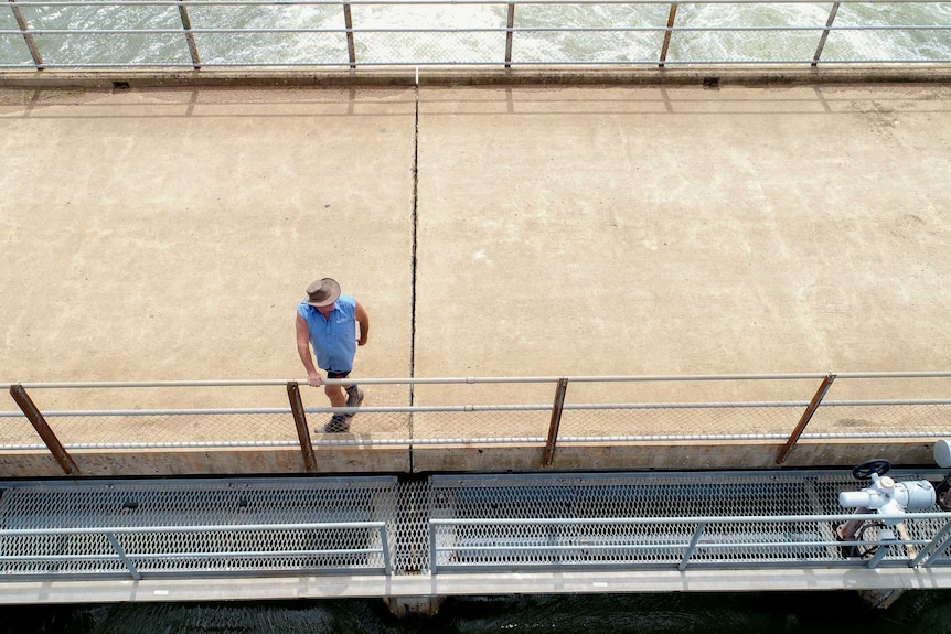 Aerial view of a man standing on a bridge over irrigation channel