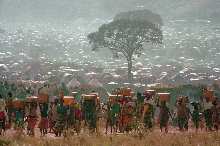 Dozens of people carry their possessions on their head in 1994.