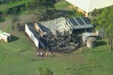 An aerial shot of a large farm shed that has been destroyed by fire.