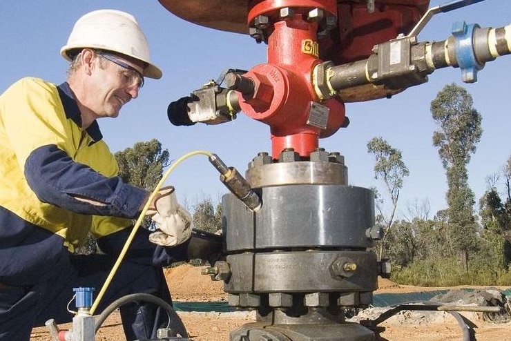 A worker fiddles with a coal seam gas drill.