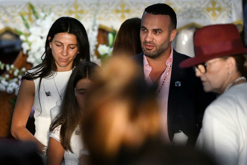 Parents Leila and Danny Abdallah are escorted to their seats at the funeral of their children.