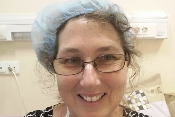 Mary Cullinane looks into the camera smiling, wearing a hair net. 