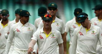 The Australian cricket team walk towards the camera.